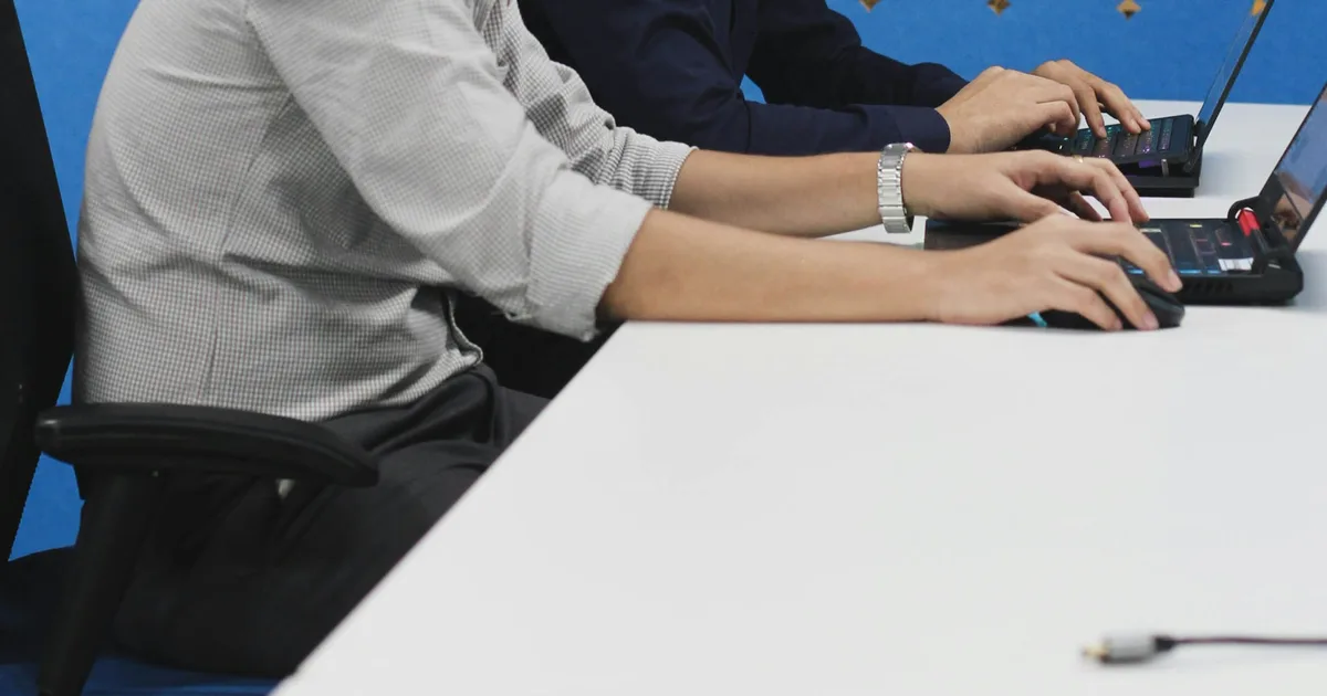 A corporate team collaborating over laptops