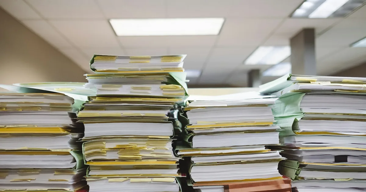 A stack of printed documents on a reading desk