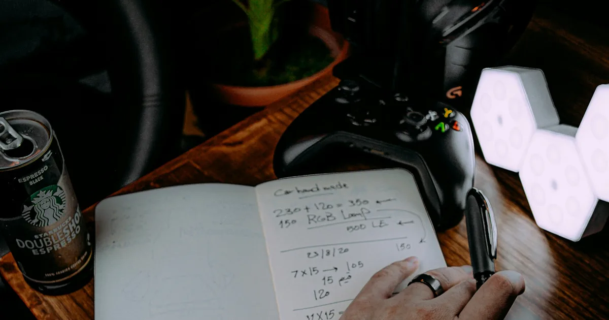 Hands typing notes on a smartphone at a wooden desk