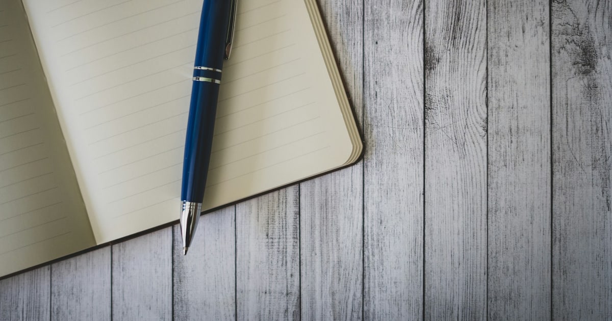 Open notebook with structured meeting notes showing decisions, owners, and deadlines