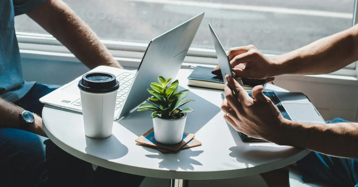 Two people talking across a table in a business meeting