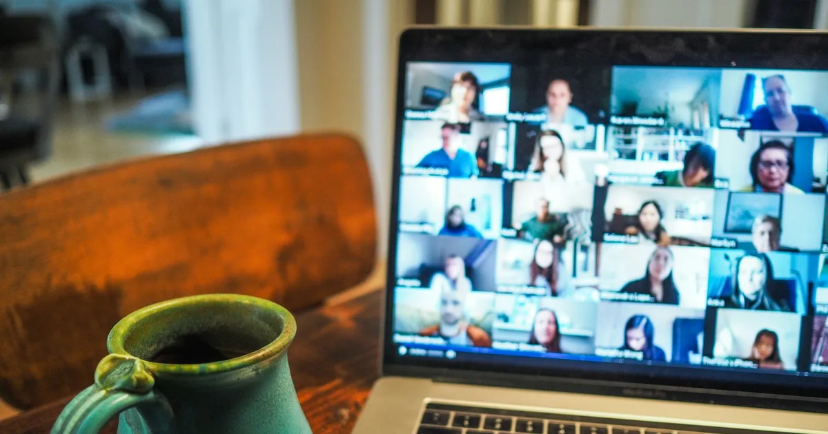 A laptop on a desk showing a video call in progress