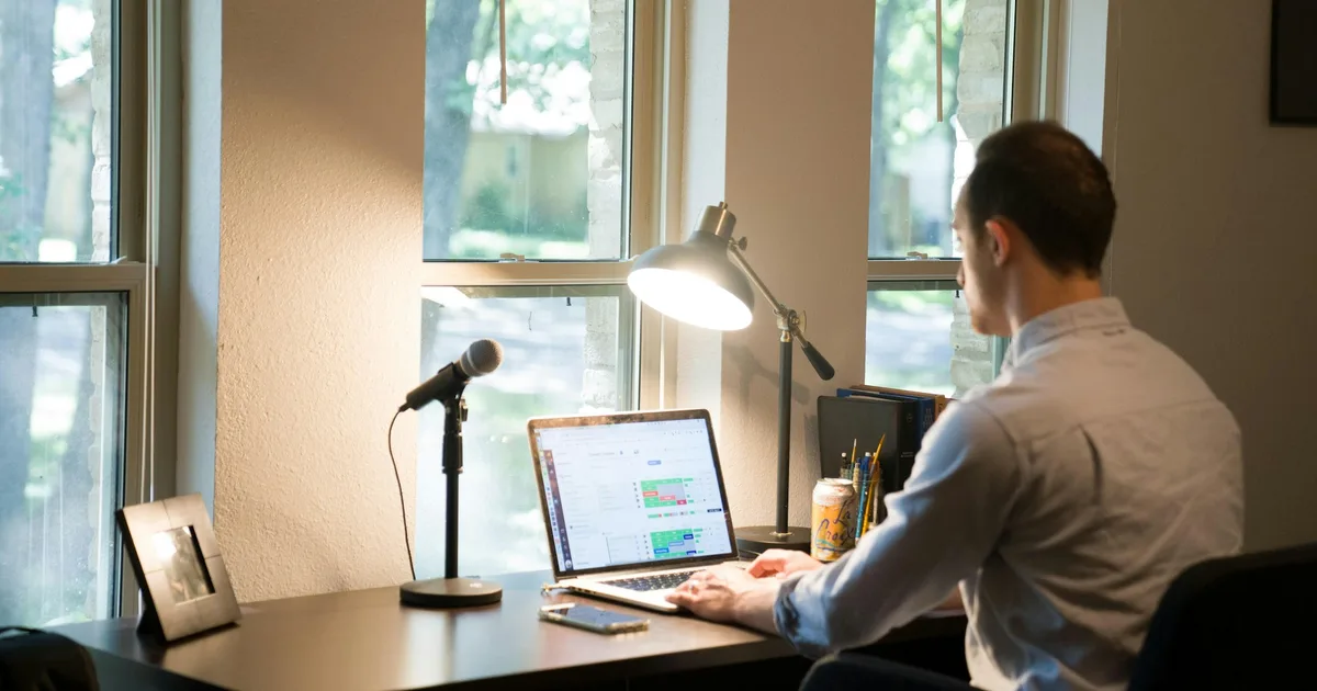 A remote worker on a video conference call at a home desk