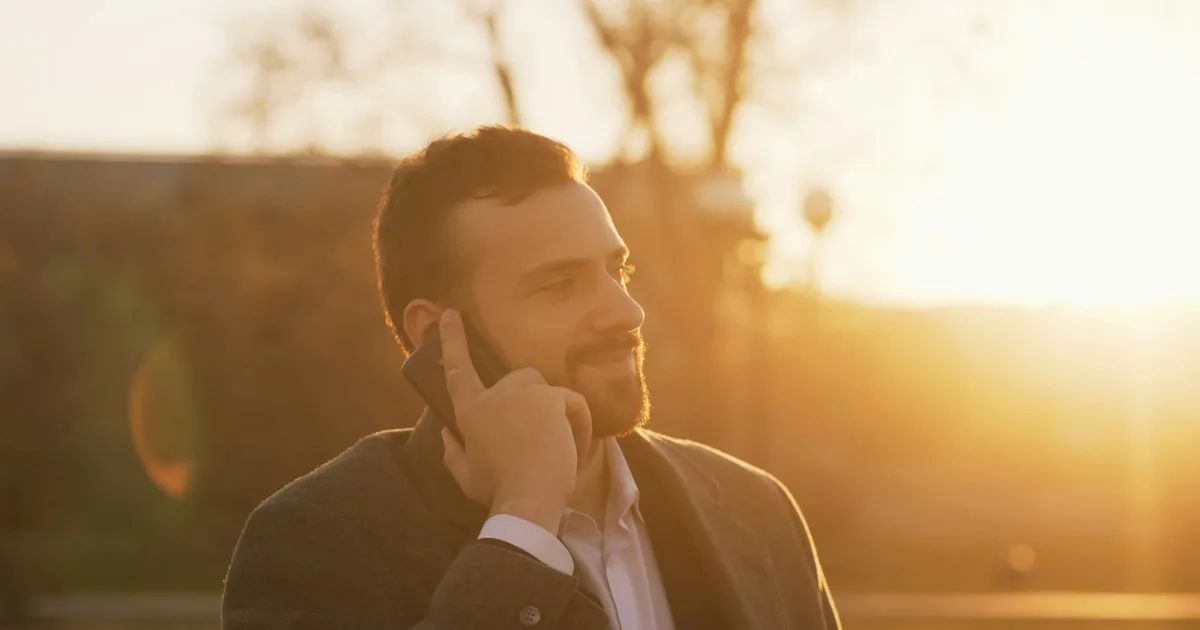 A professional using a smartphone outdoors in daylight