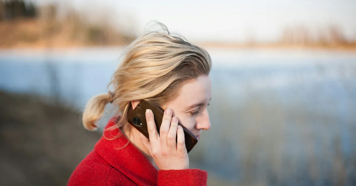 Someone speaking into a phone held close while outdoors
